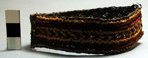 Woven armband, coarse fibre. Red and yellow design on black.