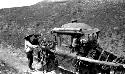 Horses carrying sedan chair, man holding one horse