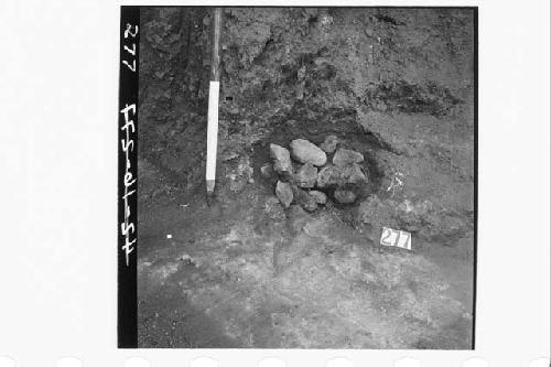 Fire-pit filled with small stones, in debris covering latest terrace floor