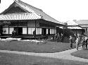 People standing on lawn near Japanese house