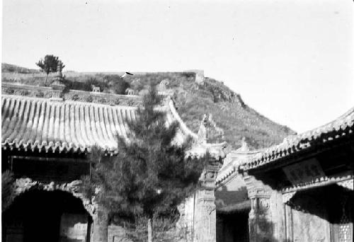 Outline of Great Wall on ridge beyond temple roofs