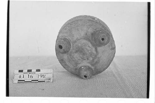 White slipped tripodal pottery bowl with traces of orange and red painted design