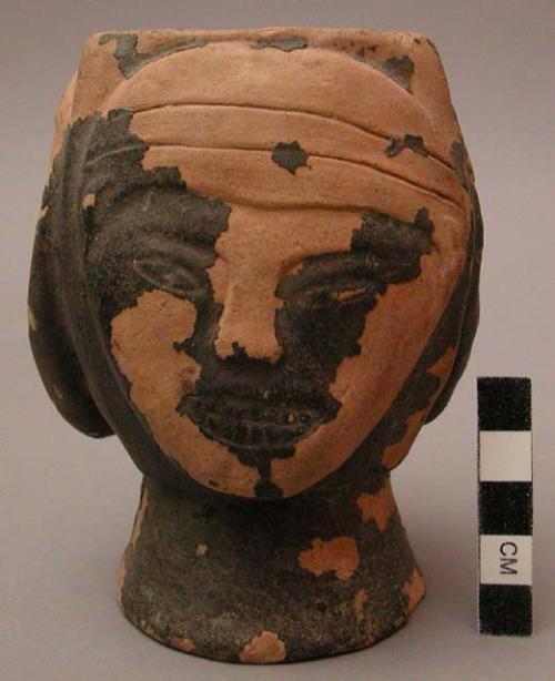 Pottery cup with decoration of three faces