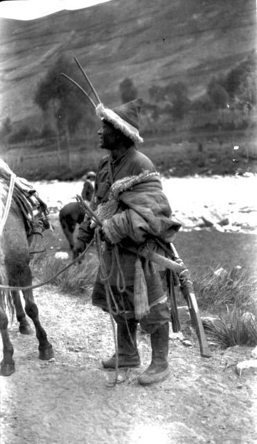 Tibetan man with rifle and horse