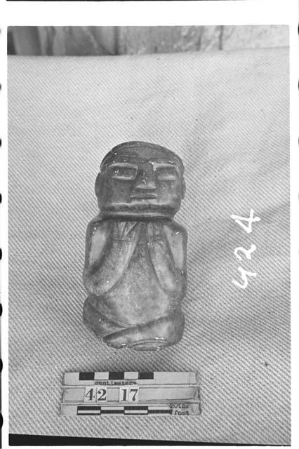 Green stone seated human figure. Hard soap stone