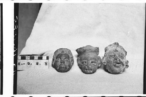 Three pottery solid figurine heads. Ext. right (#3) - traces of white slip