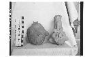 2 fragmentary Tlaloc bottles. Red clay. Faces of white paint on figure to right.