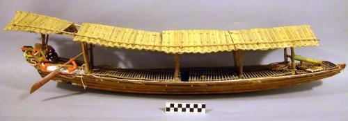 Model of war canoe, flag and paddles