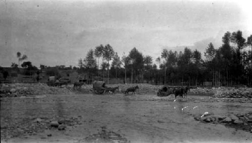 Horses pulling wagons, crossing river