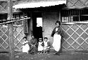 Woman with children outside doorway to house