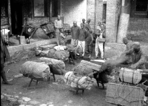 Men in courtyard handling supplies