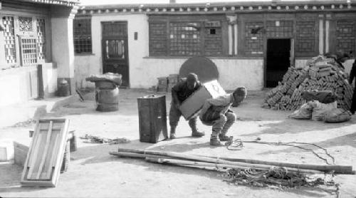 People lifting boxes outside of building