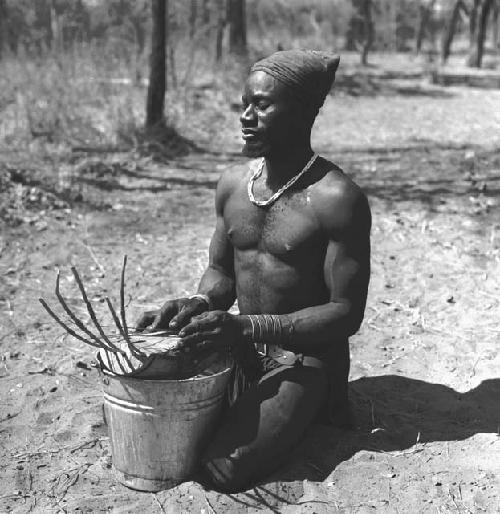 Bela playing a //guashi on a tin bucket