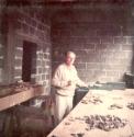 Gordon Willey sorting sherds, field house basement terrace, Copan village