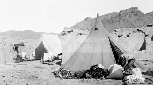 People and tents by ruins of building