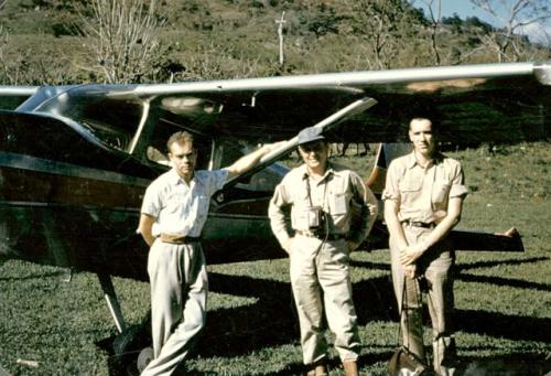 Gordon Willey between 2 unidentified man with airplane in the background