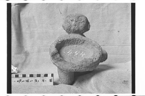 Carved stone incensario in the form of seated human figure holding bowl