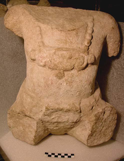 Trunk of seated human figure, arms and legs broken off.