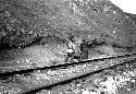 Men carrying heavy object along railriad tracks