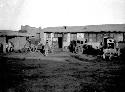 Person walking by carts toward house in courtyard