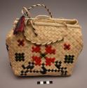 Plaited pandamus leaf purse, with multi-color woven motifs.