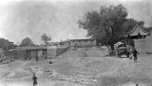 People on bridge; man, child, and pony with cart in foreground