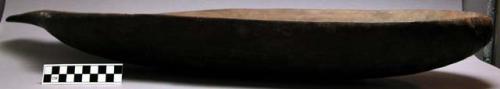Elongated wooden dish, used for food, carved by men.