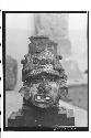 Large pottery head, wearing saucer ear-plugs, with holes in eyes,  large mouth