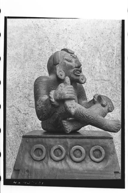 Large pottery figure seated cross-legged with body scarified or tatooed
