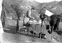 Chinese man preparing food at table, mountain background