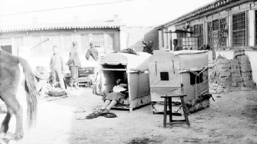 People outside building, two camel carriers