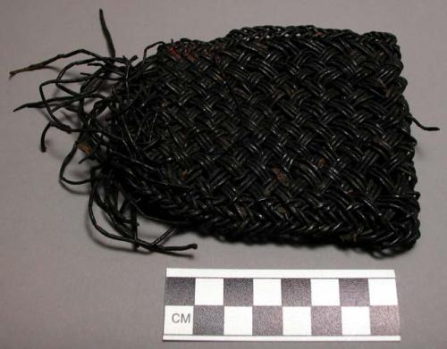 Wristband woven from black vine called "kwenit."  Kept in place by +