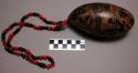 Painted pit or pod, with figurative motifs, among them a standing black figure w