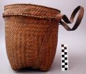 Basket, woven plant fiber, cylindrical, squared base, loops, braided straps