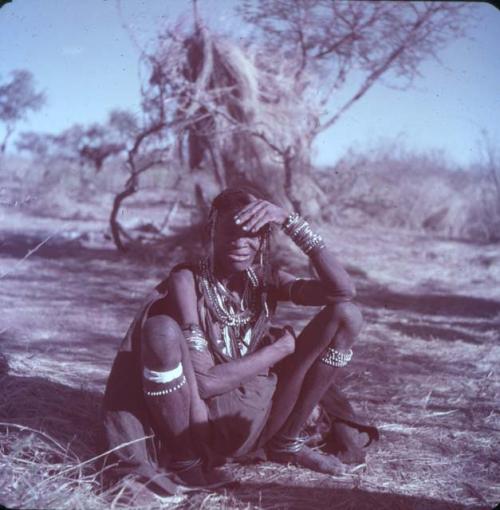 Portraits: "Old /Gam" (wife of "Old ≠Toma" of Band 2) sitting, holding her hand over her eyes