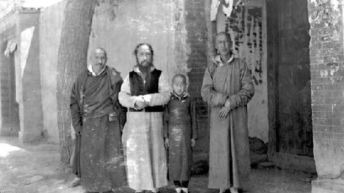 Three men and a boy standing by wall