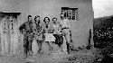 Five people posing in front of building