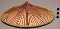 Hat, shallow cone of natural wood with red cane strips radiating from the top ce
