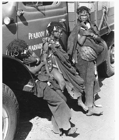"Little N!ai" (left) and two unidentified girls leaning against an expedition truck