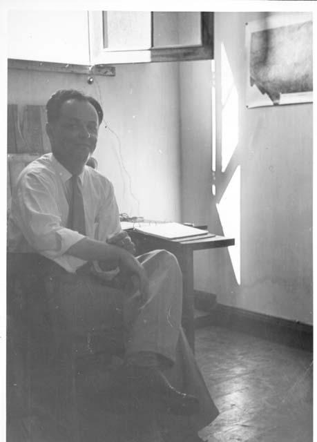 Gordon Willey seated at a desk below a window.