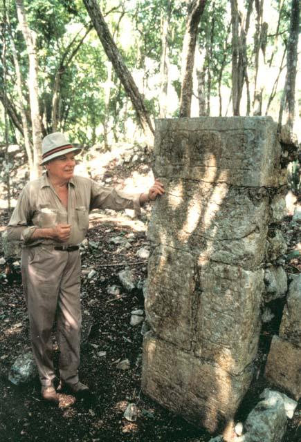 Gordon Willey standing next to a stele, probably at Chitzen Itza