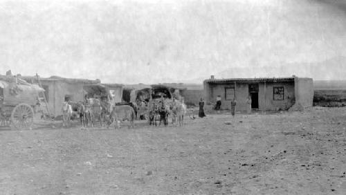 Ponies and carts by buildings