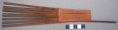 Vertical wooden comb with teeth, of the three which originally were +