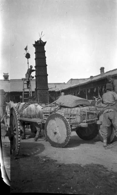 Pony and cart by building with tower