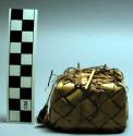 Small basketry box with lid of natural colored palm leaf. Contains betel nuts.