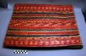 Fibre sleeping mat of red, black, yellow and cerise strips, many of +