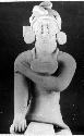 Ceramic figurine, seated male, earrings and gorget