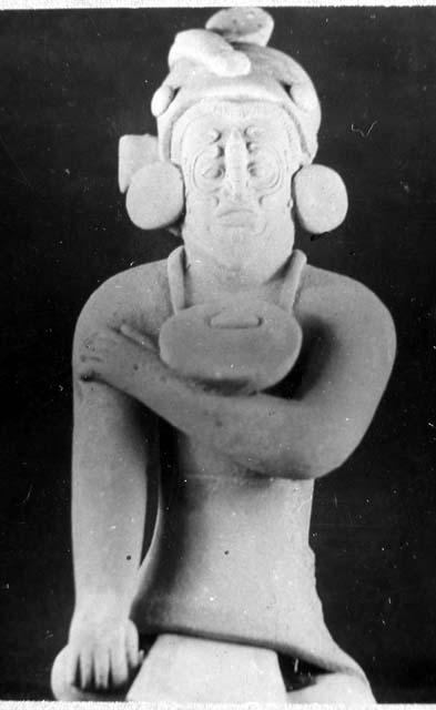 Ceramic figurine, seated male, earrings and gorget