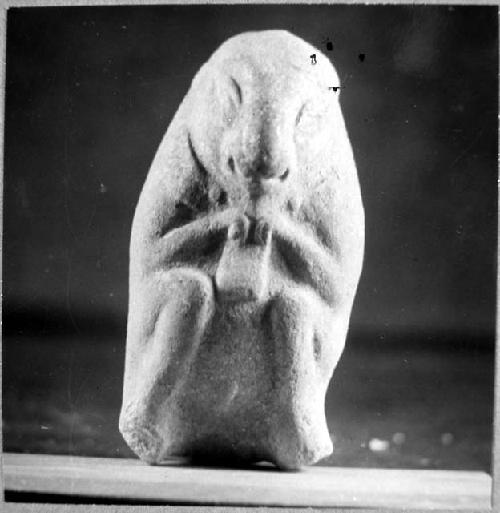 Ceramic? figurine, crouching animal holding rectangular object. 0.67, III, 39-Bi