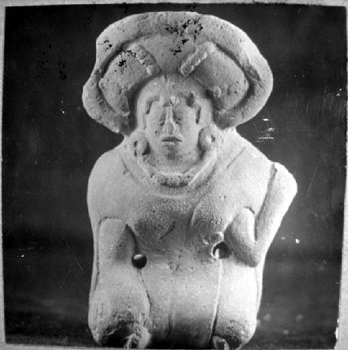 Fgurine, seated human, corona-like headdress, 2 perforations. 0.31, 18-Bis